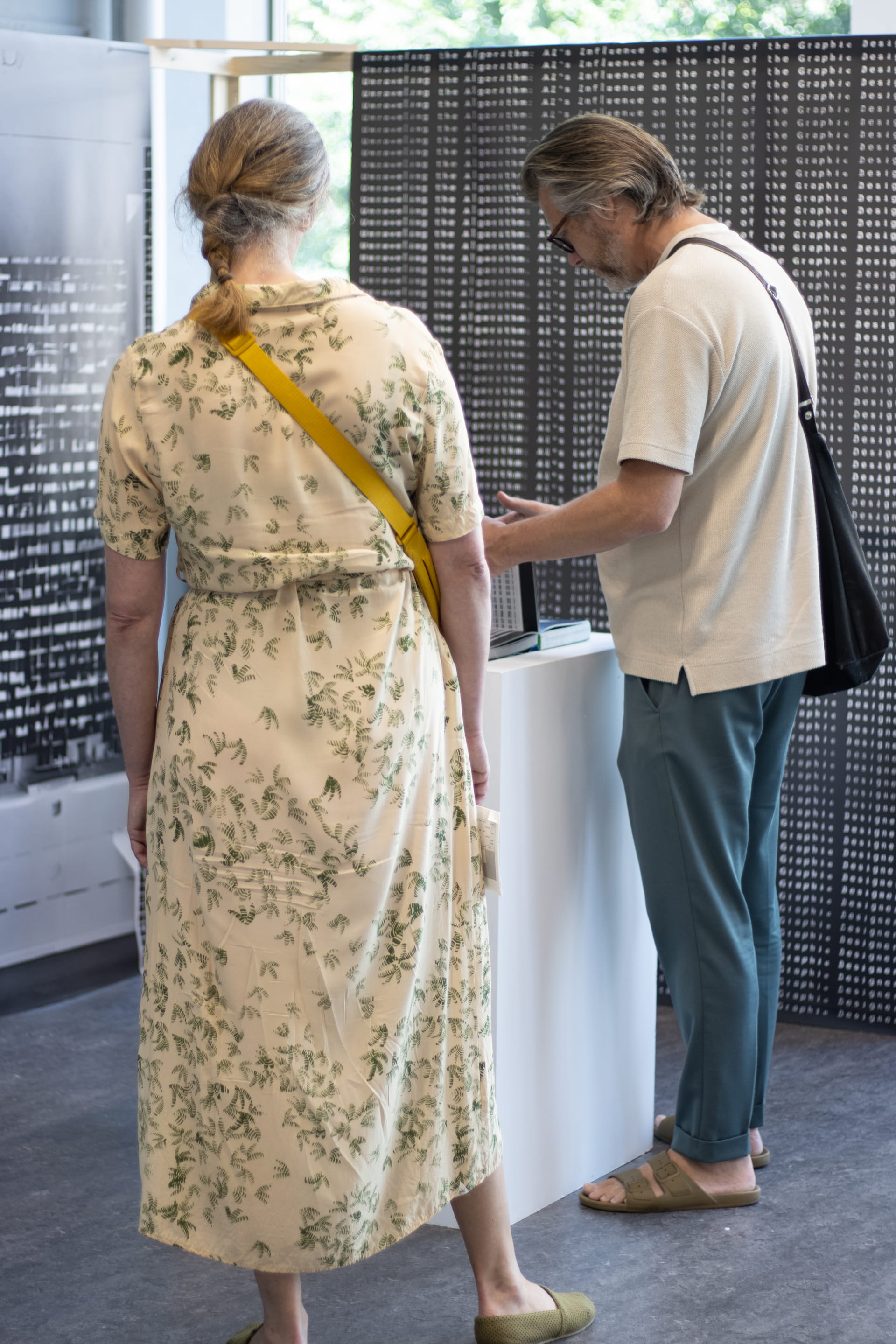 Mensen kijkend naar het boek Unraveling the Algorithm tijdens de expositie.